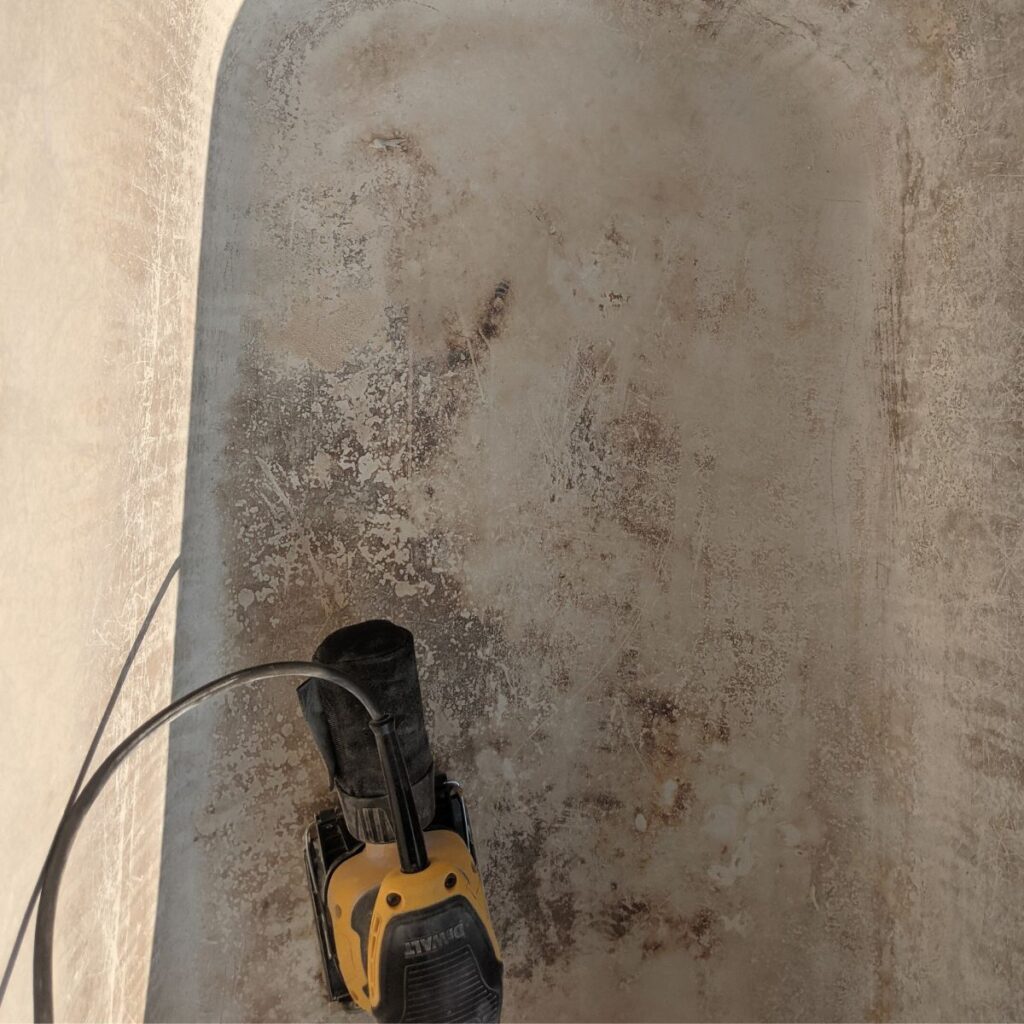 an electric sander inside a clawfoot tub