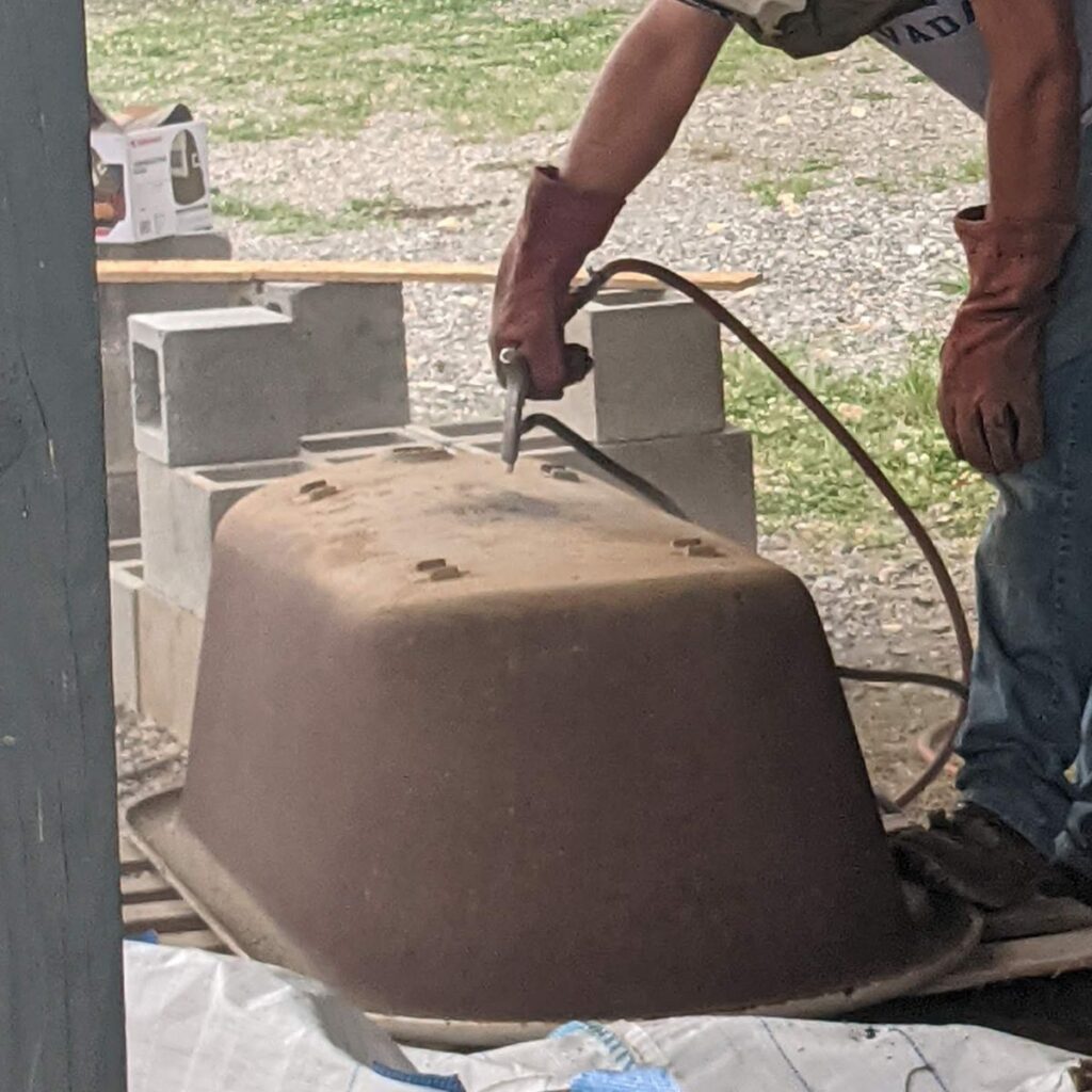 man sandblasting a clawfoot tub