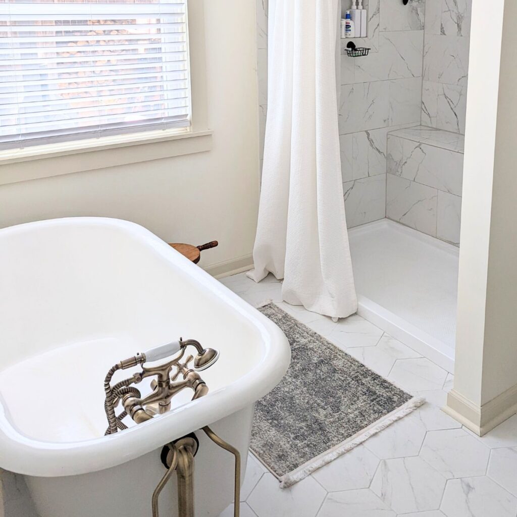 bathroom with a clawfoot tub and tile shower