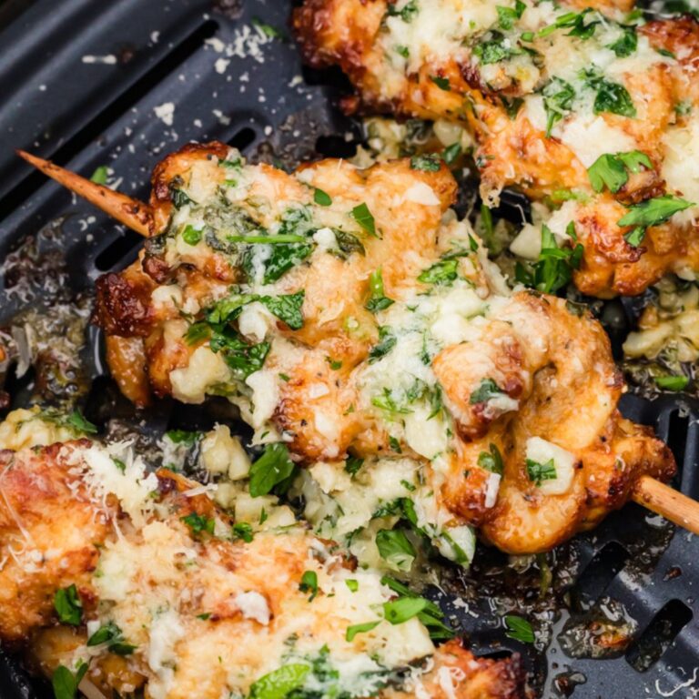 three garlic parmesan chicken skewers in an airfryer basket